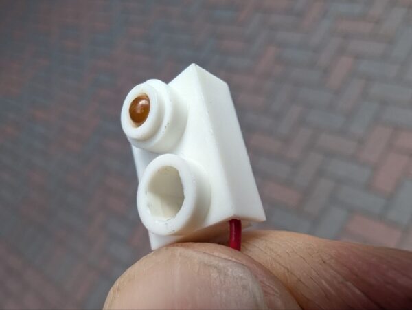 Ein neuer S26 Sensor vor dem Einbau in den HCEF-Transportbereich einer Relay 7000 Kuvertiermaschine.